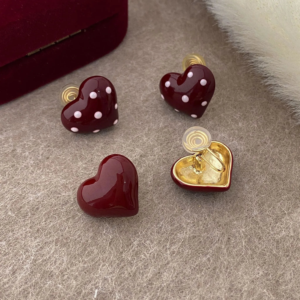 Red drip glaze heart earrings in copper, shown as no-piercing ear clips and stud earrings