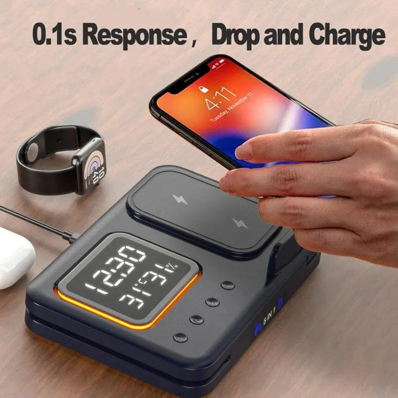 Black 5-in-1 wireless charging station displaying time and temperature, charging a phone and a smartwatch.