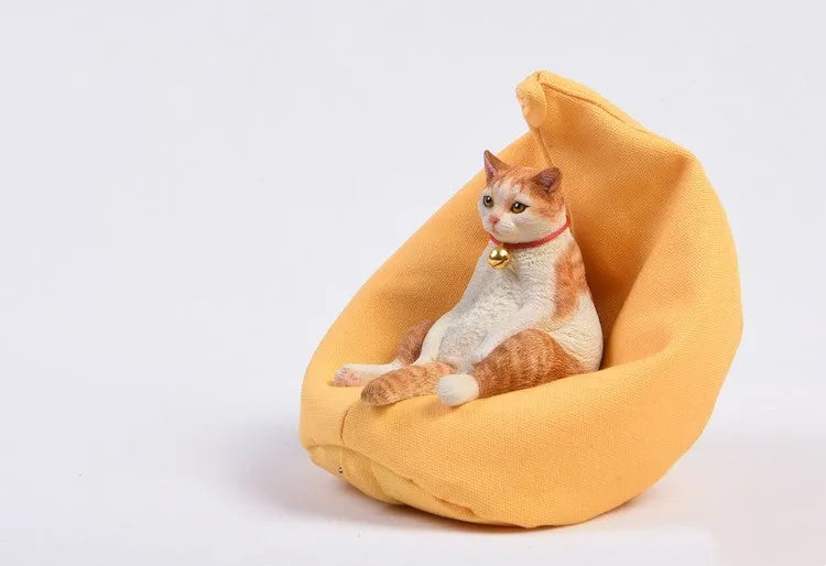 Small resin cat figurine on a sofa, a 1:6 scale car dashboard ornament.