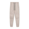 Man wearing dark grey loose-fit fitness trousers with tied ankle cuffs, made from quick-dry polyester fabric.