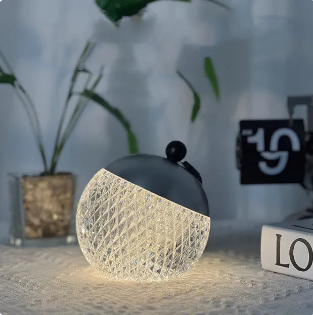 Portable cylindrical night lamp with touch control in metallic finish on wooden table