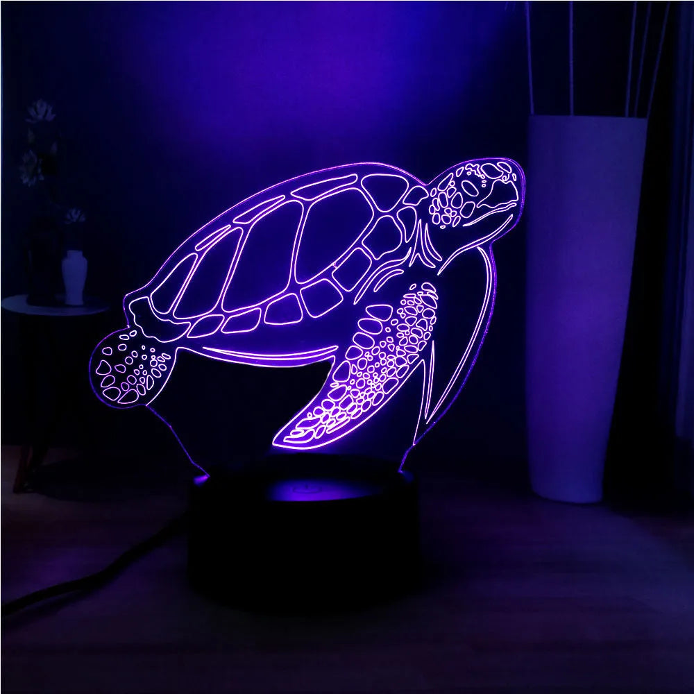 3D acrylic turtle-shaped LED night light with remote control on a bedside table.