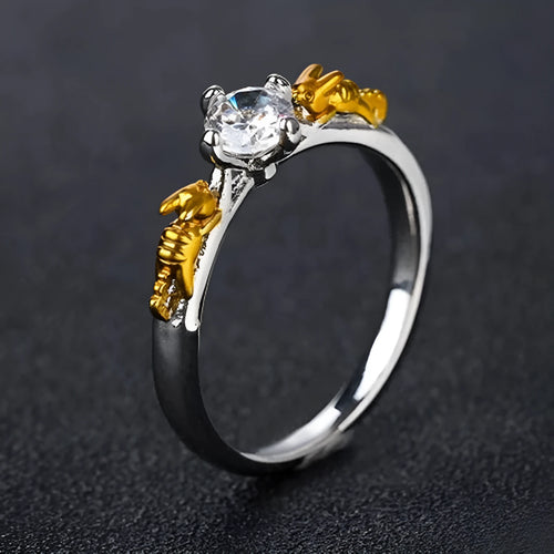Close-up of a black gold copper ring with a detailed three-dimensional crown design on a finger.