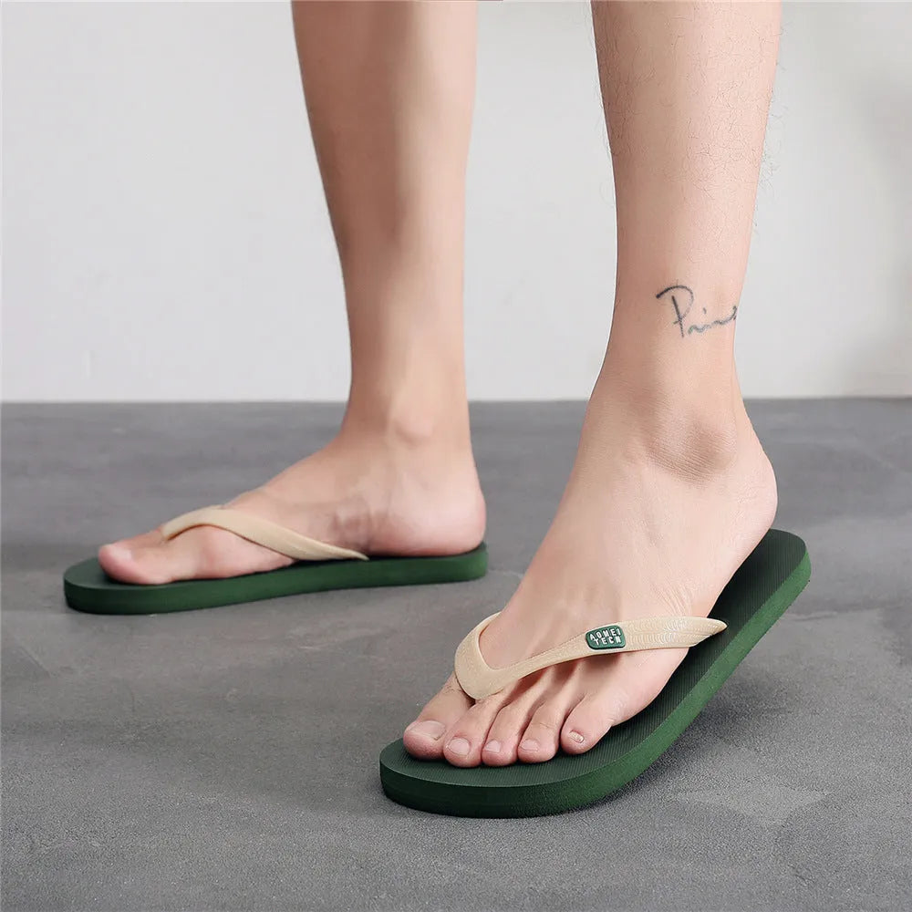 Men's black rubber sole flip-flops with an EVA foam upper on a wooden deck