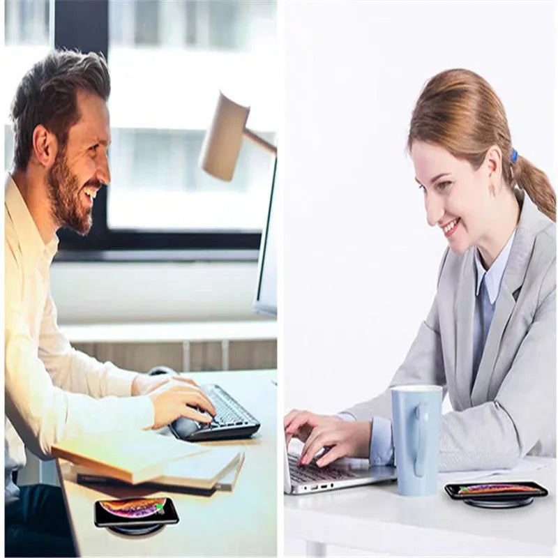 Black aluminium wireless charging pad on a desk with a mobile phone charging on top.