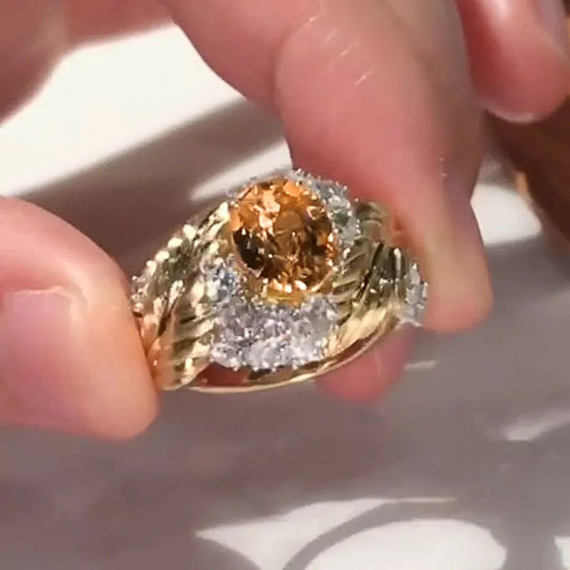 Gold-coloured copper ring with embossed feather pattern and yellow zircon stone.