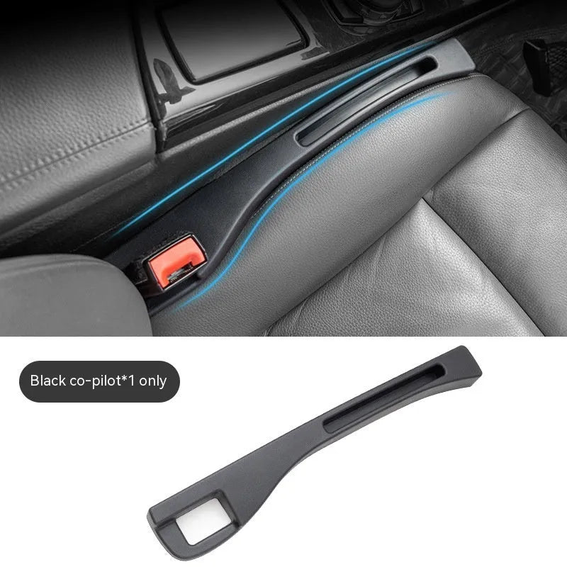 Black plastic car seat gap storage organiser box with handle inserted between vehicle seats