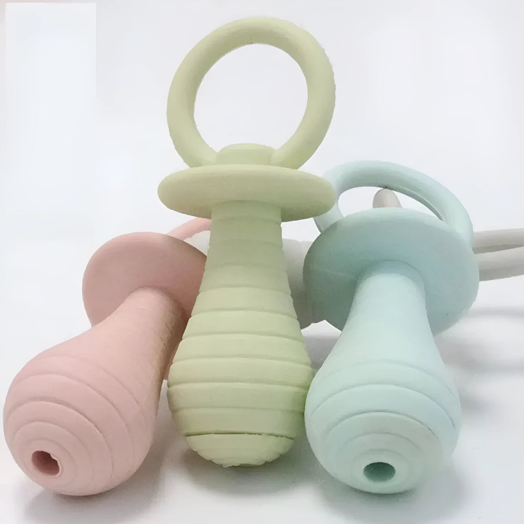 Four coloured TPR rubber pacifier-style pet chew toys with squeakers for puppies and kittens.
