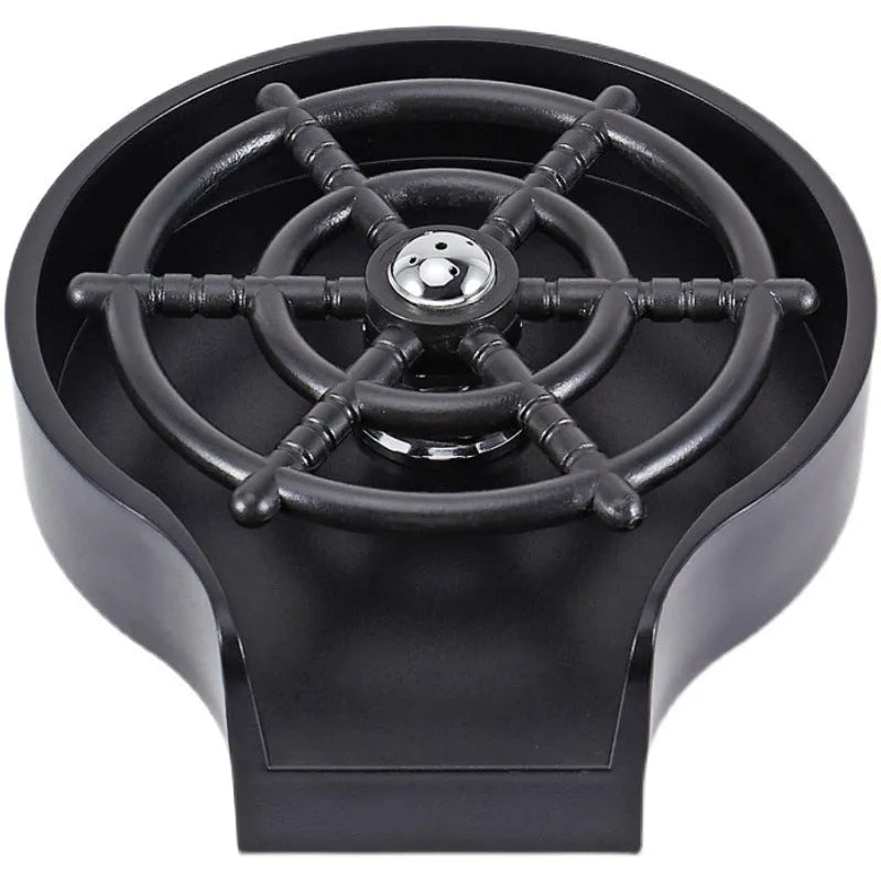 Black automatic cup washer with five-hole nozzle installed on a bar counter sink with a glass being rinsed