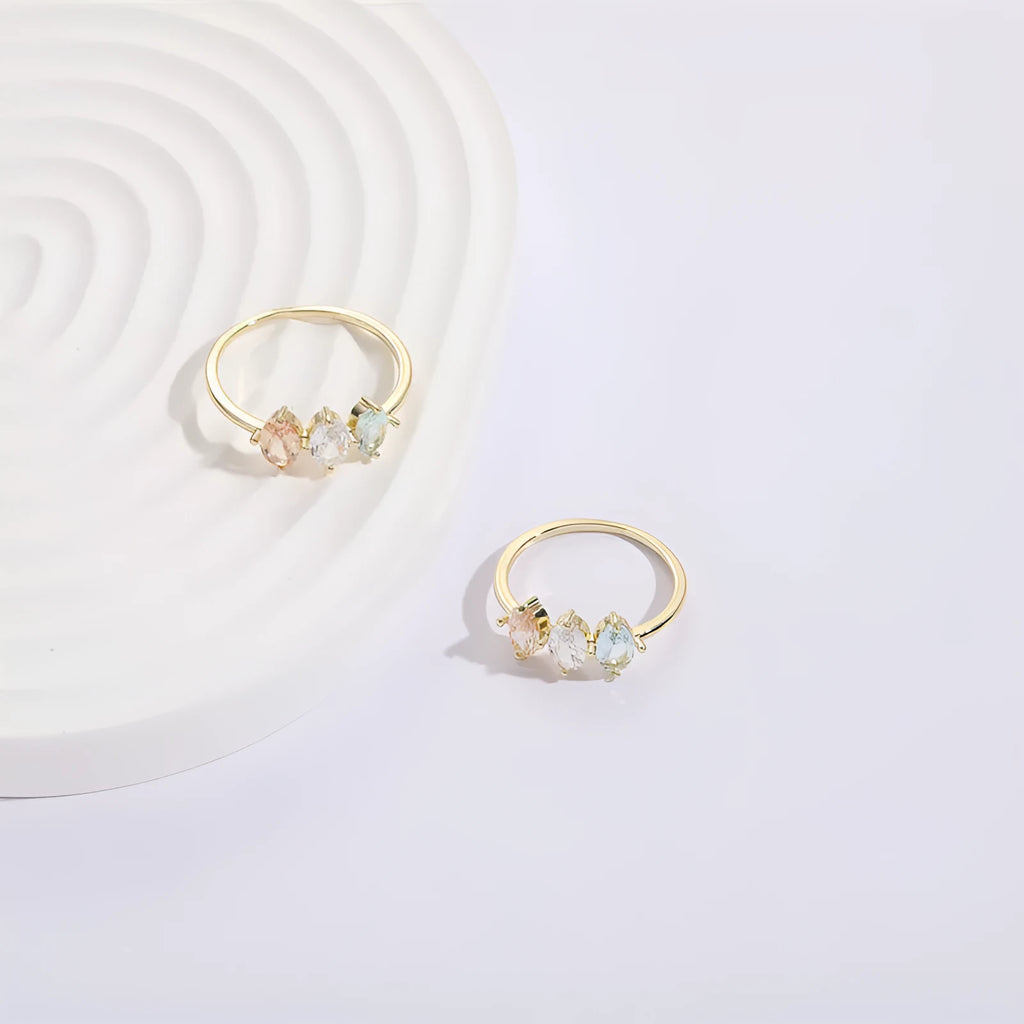 Geometric copper ring with a triangular tricolour zircon birthstone in a horse eye design, showing 14k gold electroplated finish.