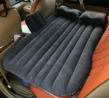 Black car inflatable bed with two pillows, shown inflated in a vehicle's rear compartment.