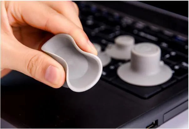 Four grey durable plastic laptop cooling pads, two large and two small, on a wooden desk.