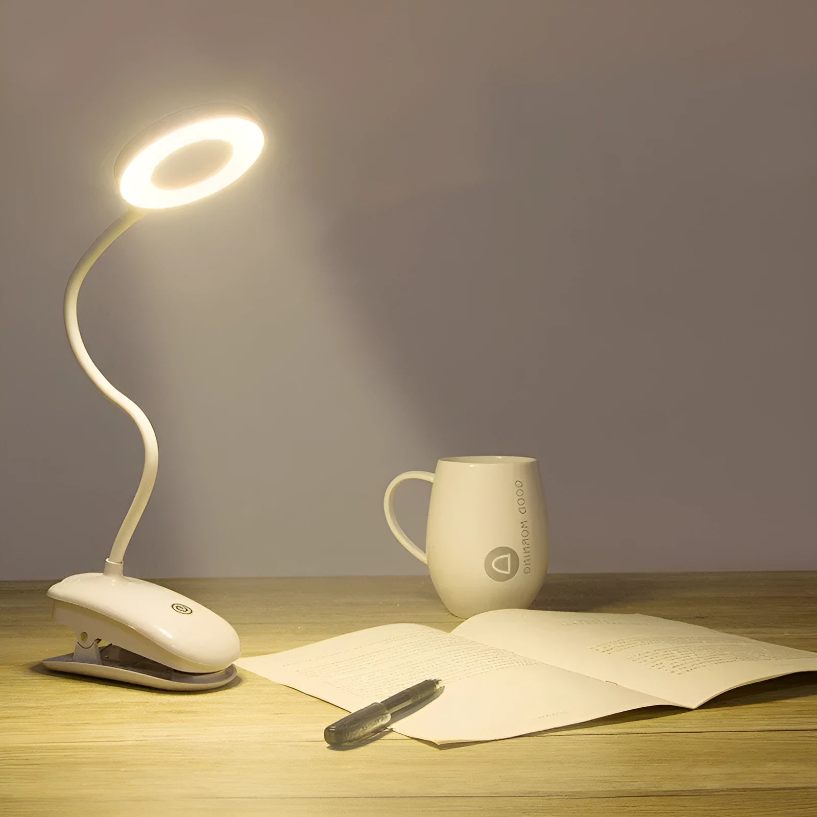 Modern clip-on rechargeable LED desk lamp with touch switch and plastic shade in use on a desk.