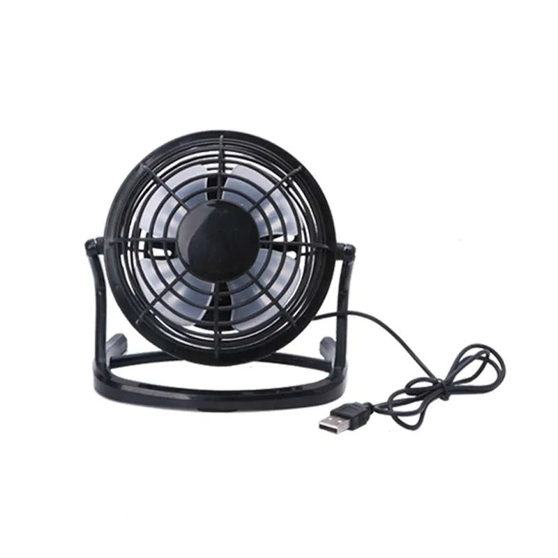 Compact black mini USB desk fan with adjustable tilt on a desk next to a laptop.
