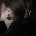 Black heart-shaped earrings with glass inlay in Korean style, shown as one pair