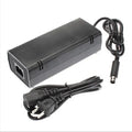 Black Xbox 360 E console AC power adapter with plug options for EU, UK, and US sockets.