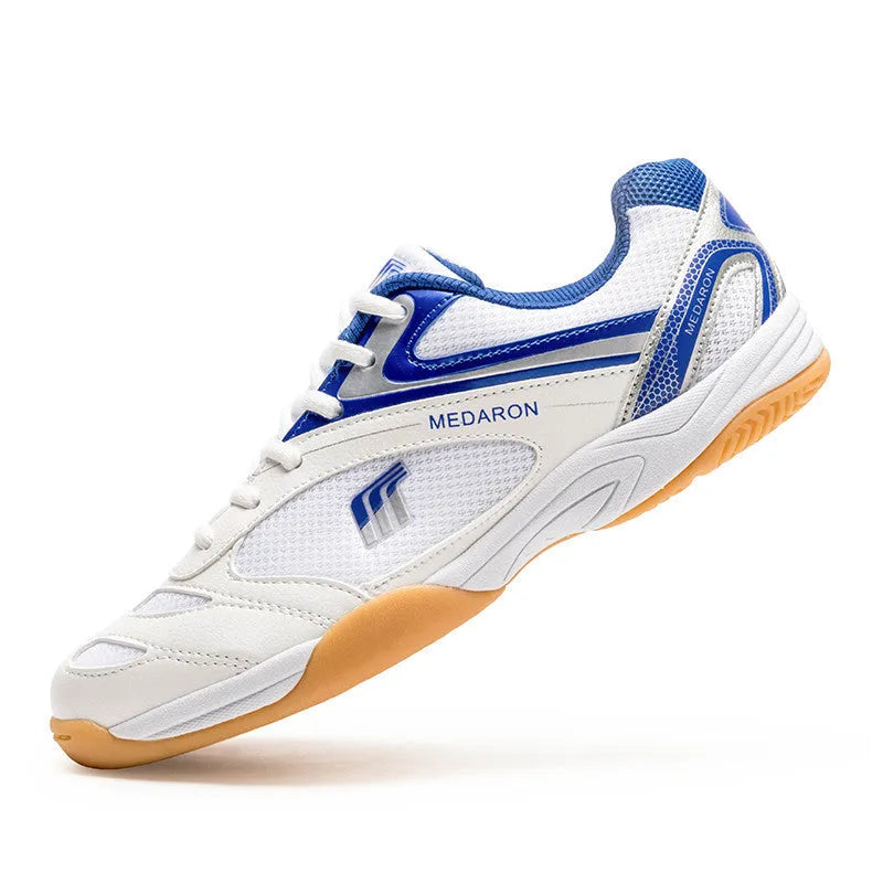 White table tennis sneakers with red accents, showing mesh panels, lace-up front, and rubber outsole.