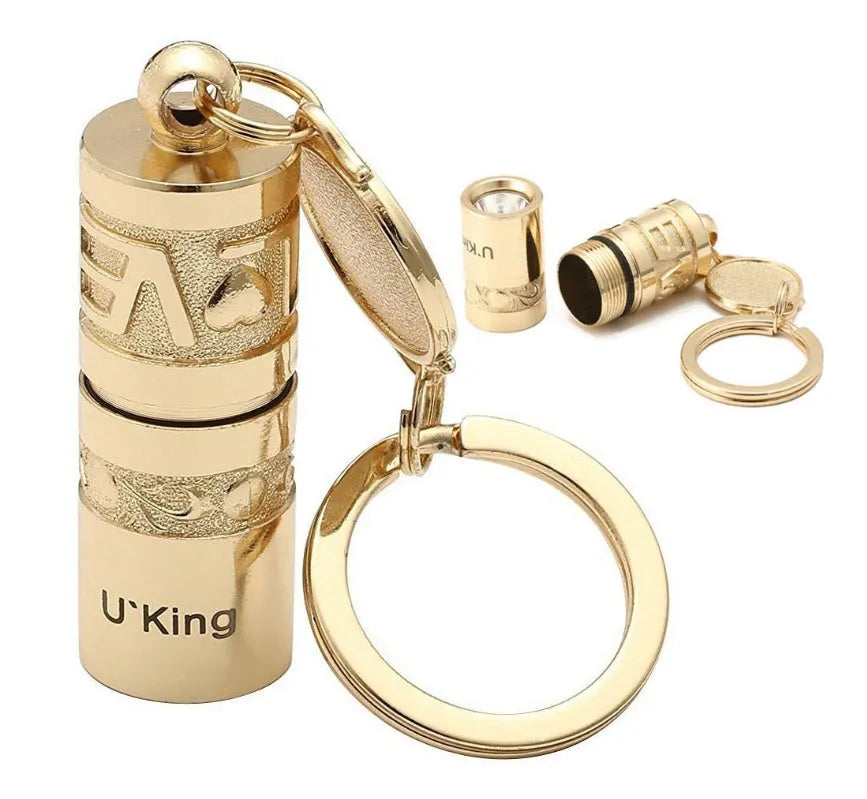 Gold-coloured zinc alloy mini LED flashlight on a keyring for outdoor and emergency use.