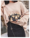 Women's black or green hard flap top shoulder bag made of PU leather with rivet details.