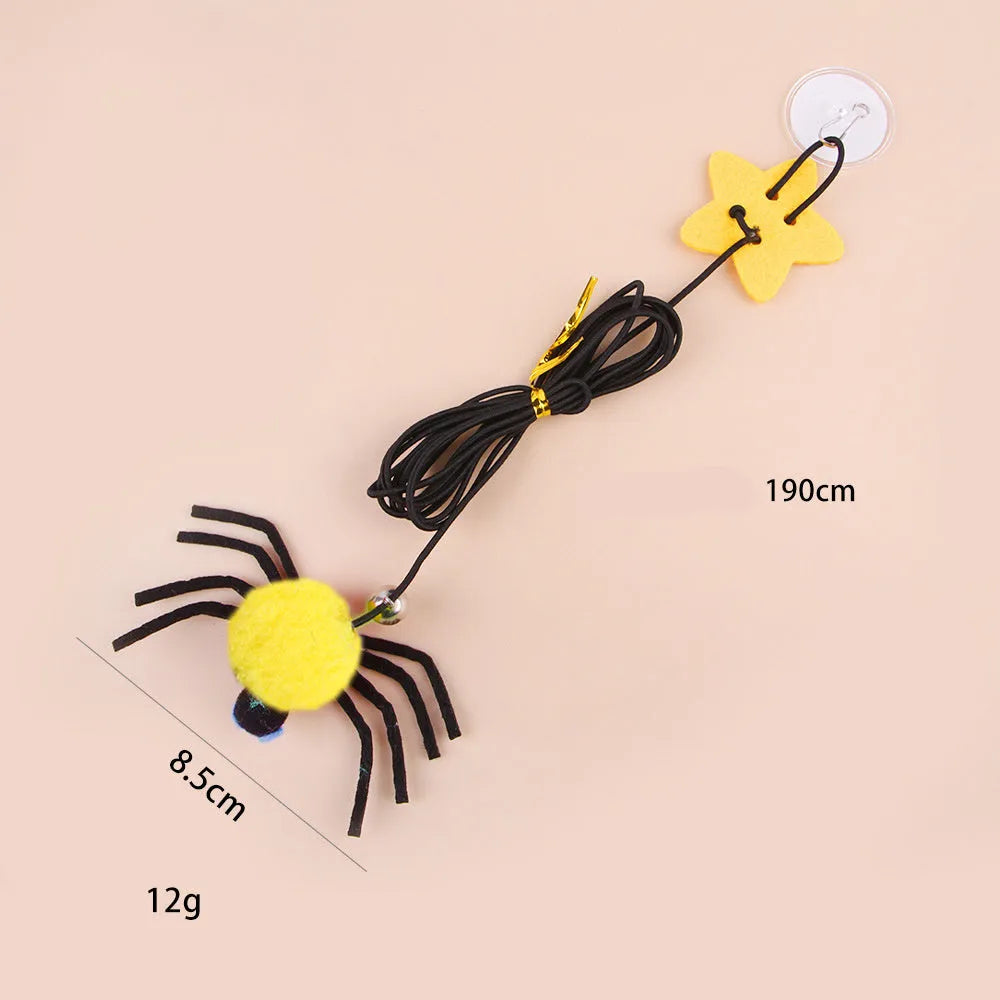 Red hanging cat toy with elastic rope, feathers, and bell spider ornament mounted on door