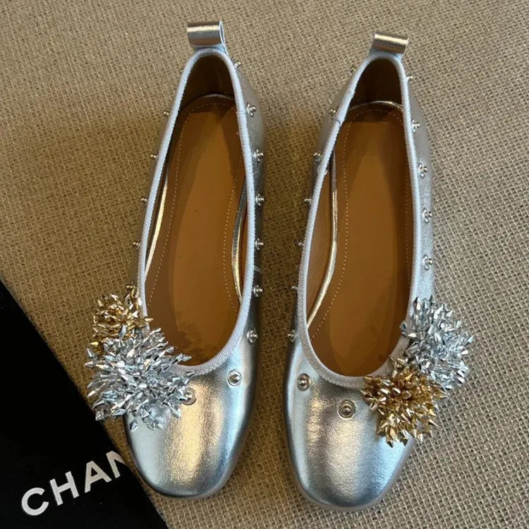 Women's silver Mary Jane loafers with flower rivets, buckle strap, round toe, and flat rubber sole.