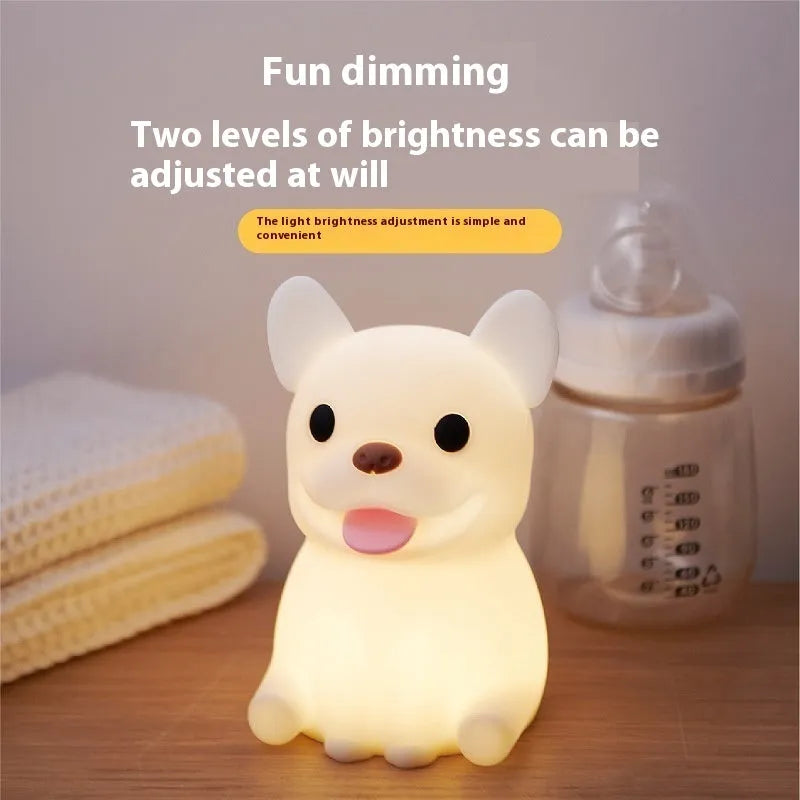A cartoon bull-shaped silicone USB night light with a dimming function on a bedside table.