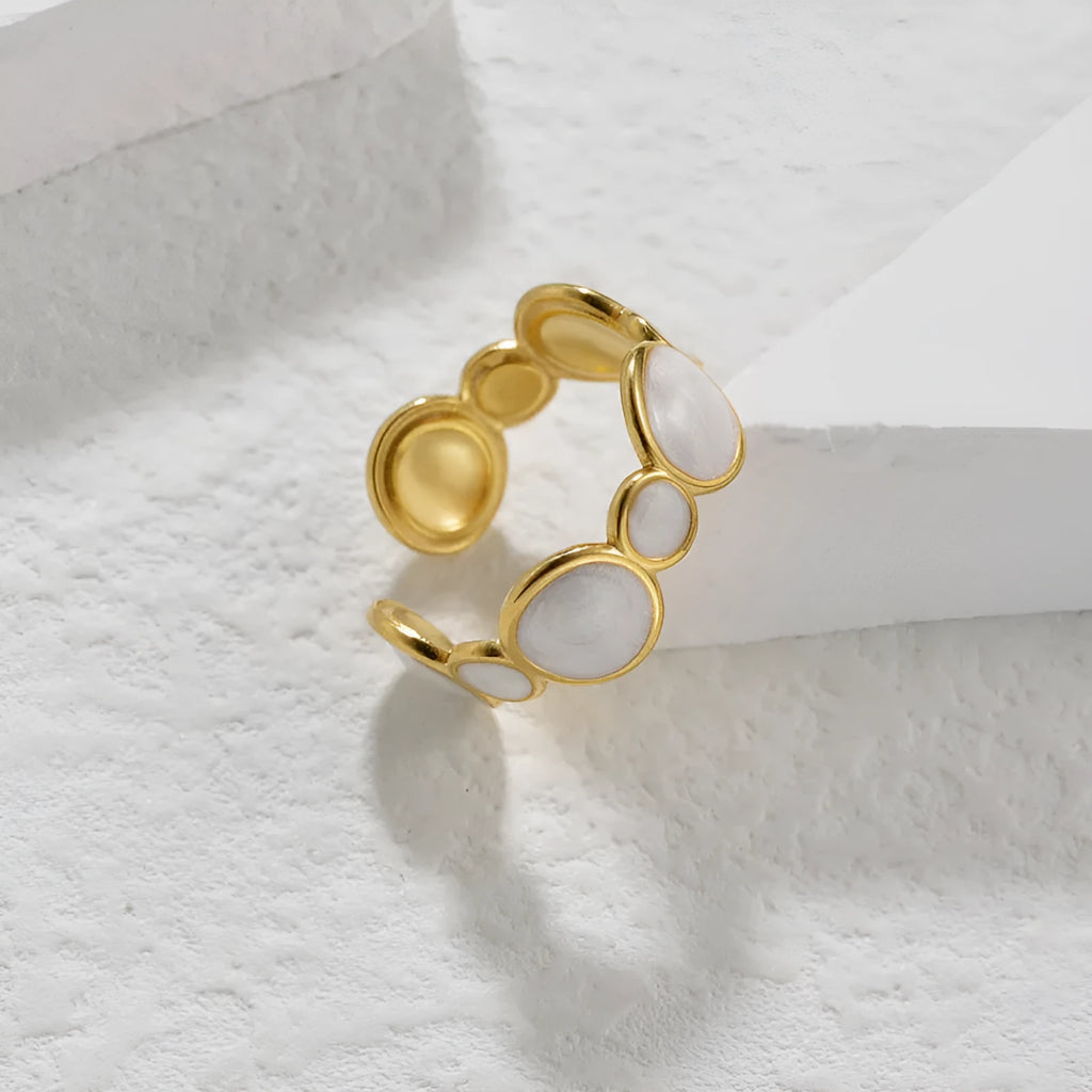 Geometric stainless steel ring with adjustable opening on a plain background.