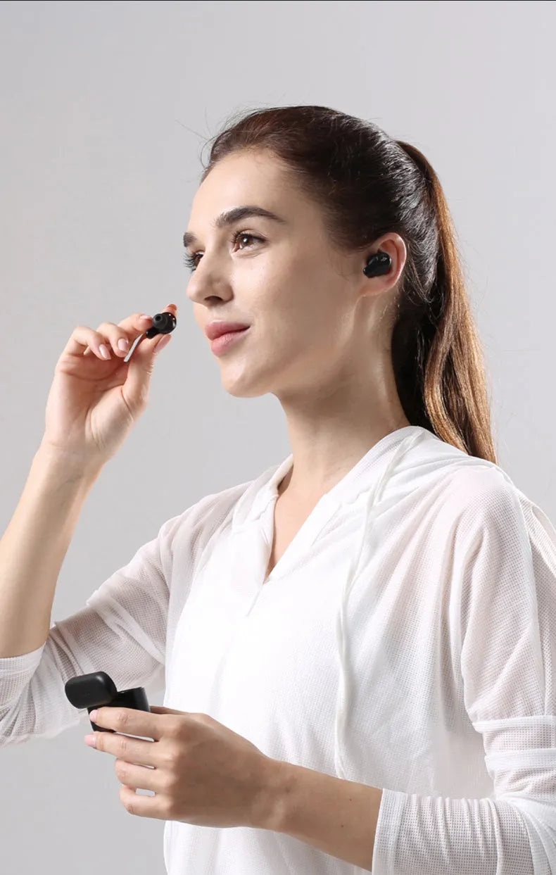 Pearl white and black true wireless Bluetooth sports headphones with USB charging cable.