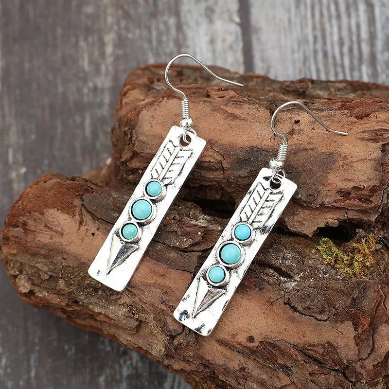 Silver long strip geometric earrings with turquoise inlay, showing front view.