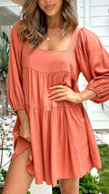 Orange red children's backless pullover dress with puff sleeves and a square collar on a mannequin.