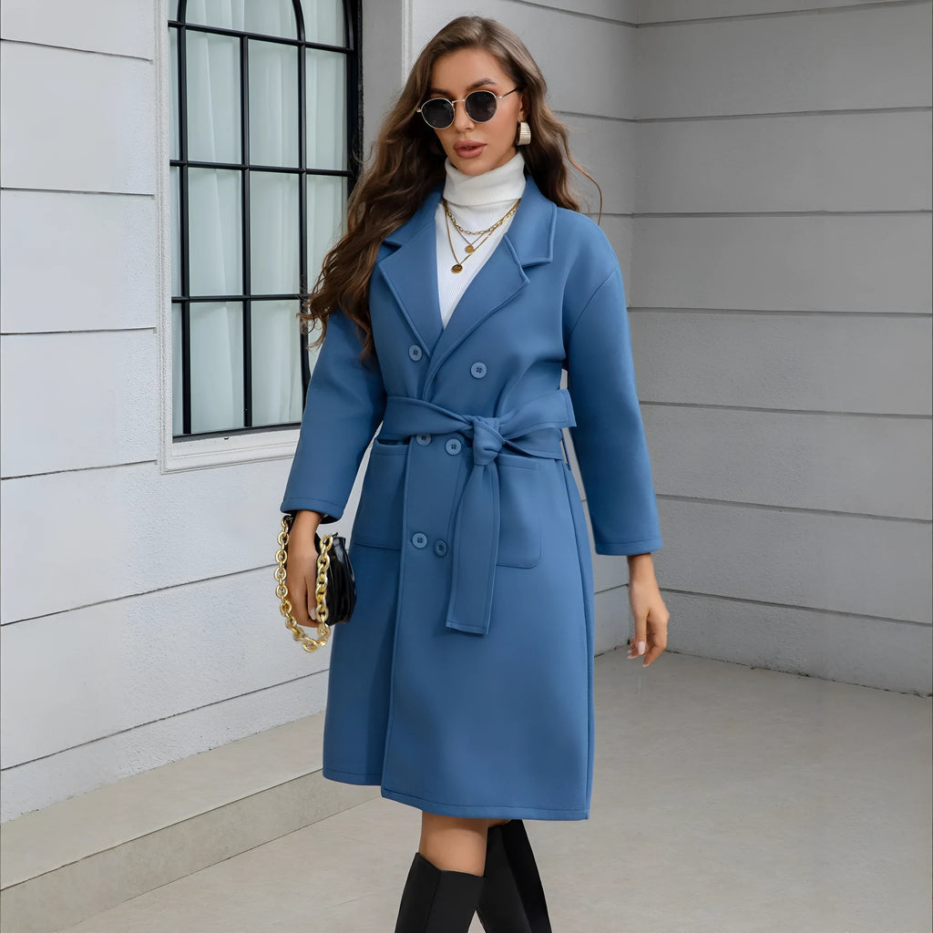 Blue waist-tie mid-length women's wool coat with long sleeves, pockets, and patchwork details