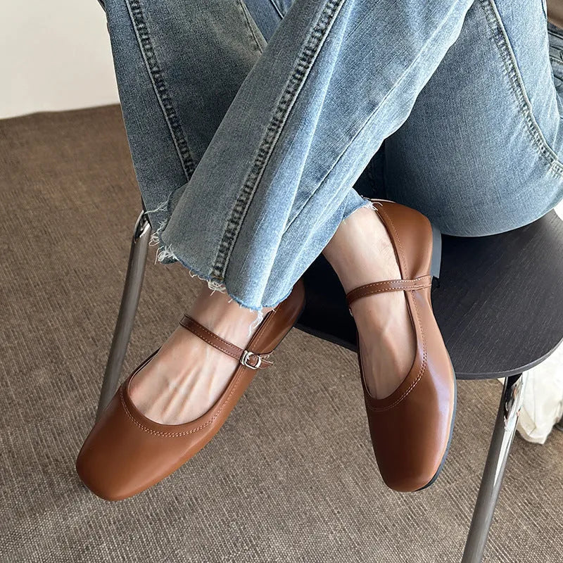 Women's black sheepskin Mary Jane flat shoes with round toe and flat rubber sole on a white background.