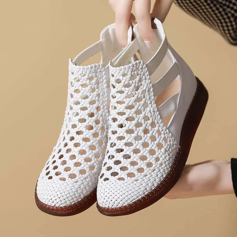 Gold flat sandals with round toe and breathable hollow-out design on a white background.
