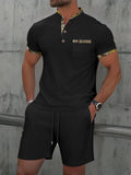 Man modelling a grey zip-front polo collar top and matching shorts, a waffle knit leisure suit set.