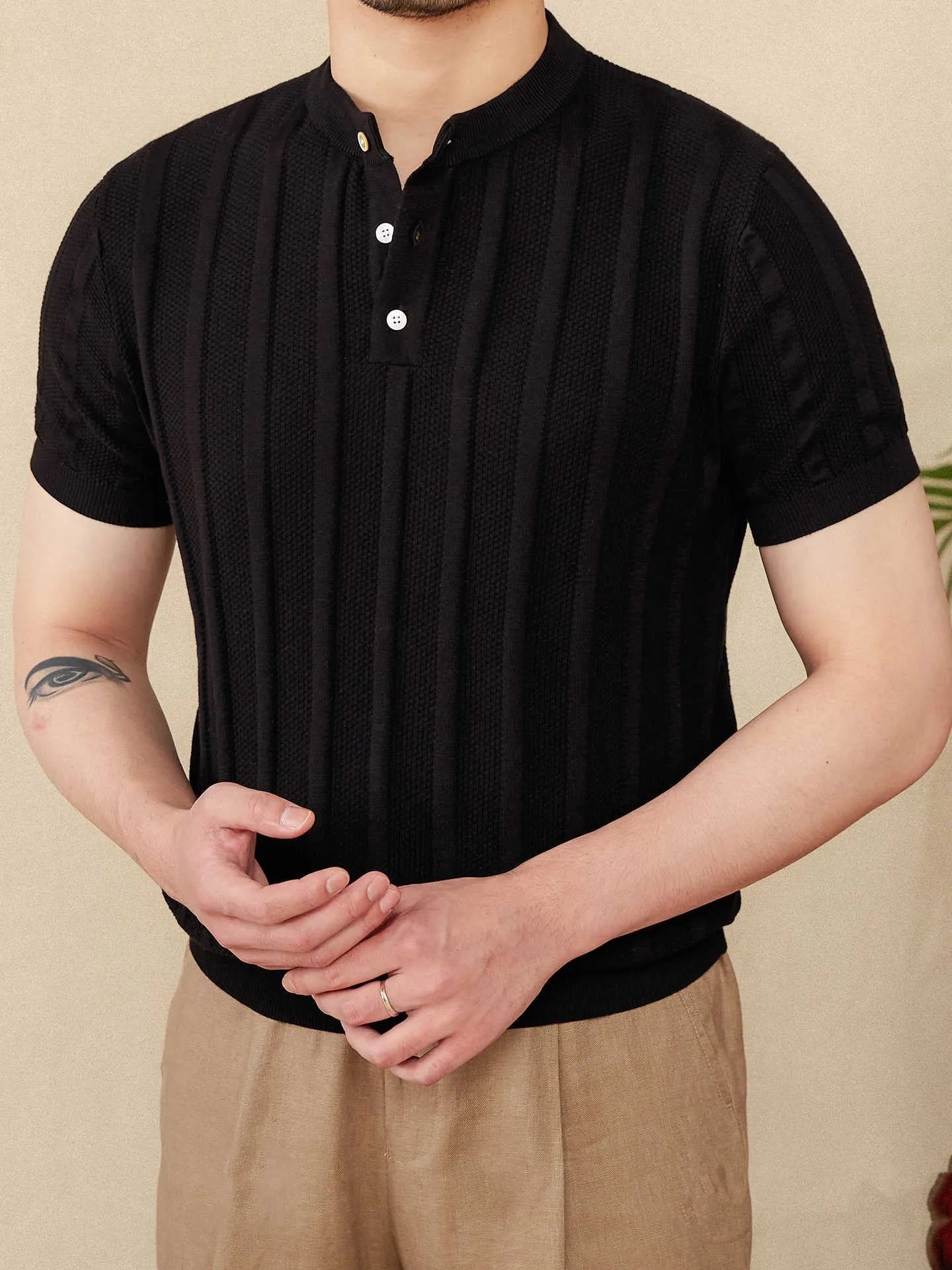 Men's creamy-white cotton short-sleeved T-shirt with a Henry collar and subtle sunken stripe pattern laid flat.