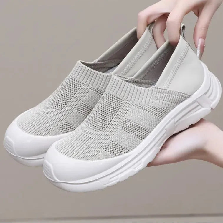 Women's black slip-on shoe cover with breathable cloth upper and flat PVC sole.