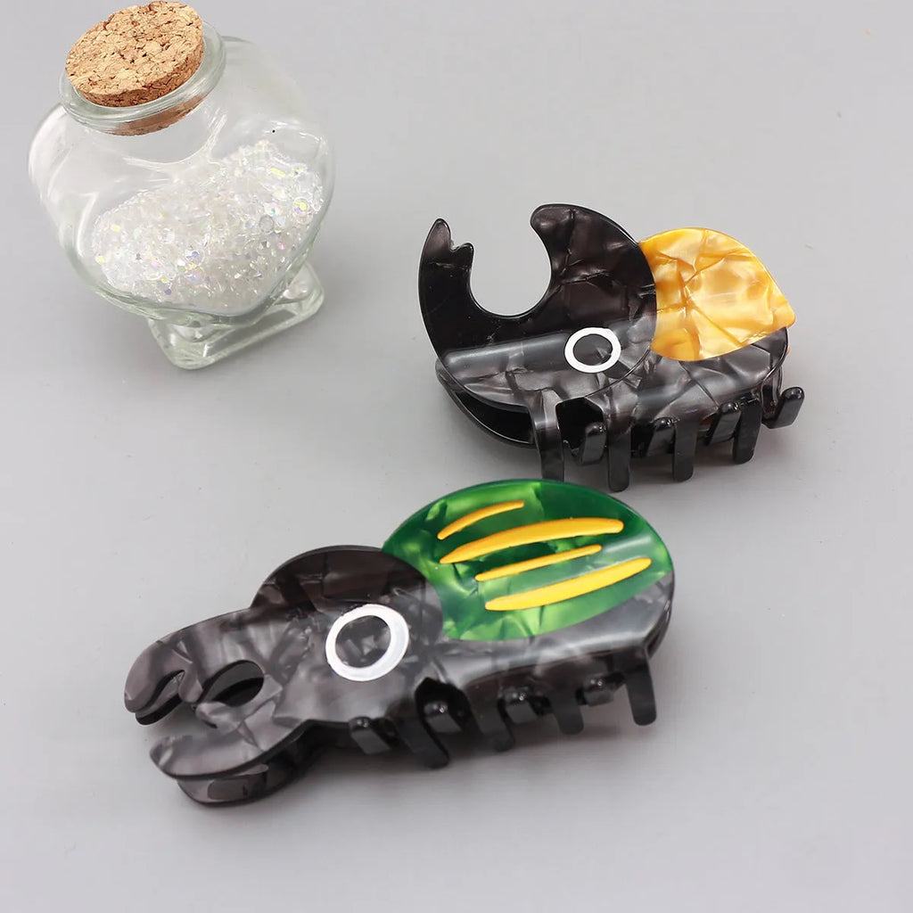 Handmade green cartoon beetle grip made from cellulose acetate sheet holding papers.