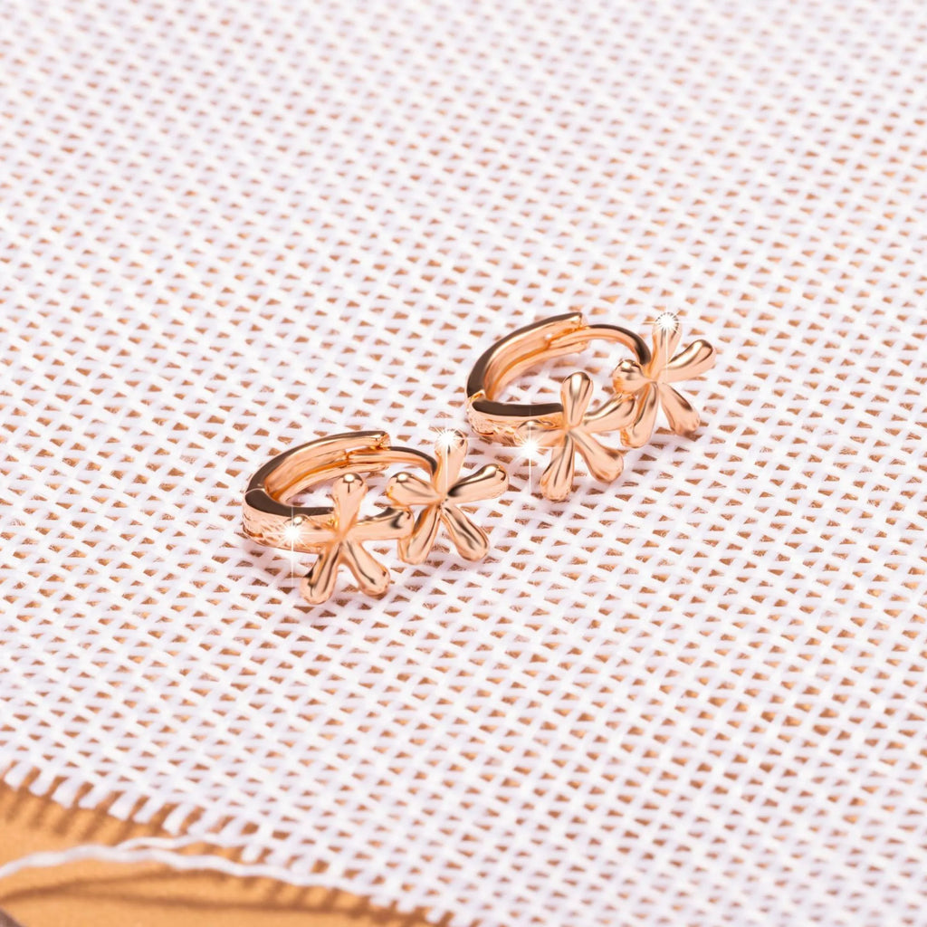Rose gold circular waterdrop flower earrings with sterling silver posts on a white background.