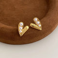 Heart-shaped pearl earrings in copper with electroplated finish, shown as ear clips or ear studs for women.