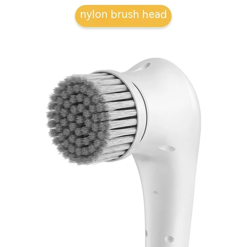 White USB rechargeable cordless electric cleaning brush with five different brush heads on a table.