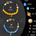 Twelve separate beaded bracelets with coloured stone beads, each on a black elastic cord, representing different zodiac signs.