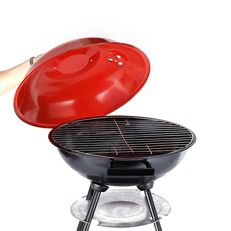 A compact, circular portable barbecue oven with a 14-inch cast iron grill grate, shown on a patio.