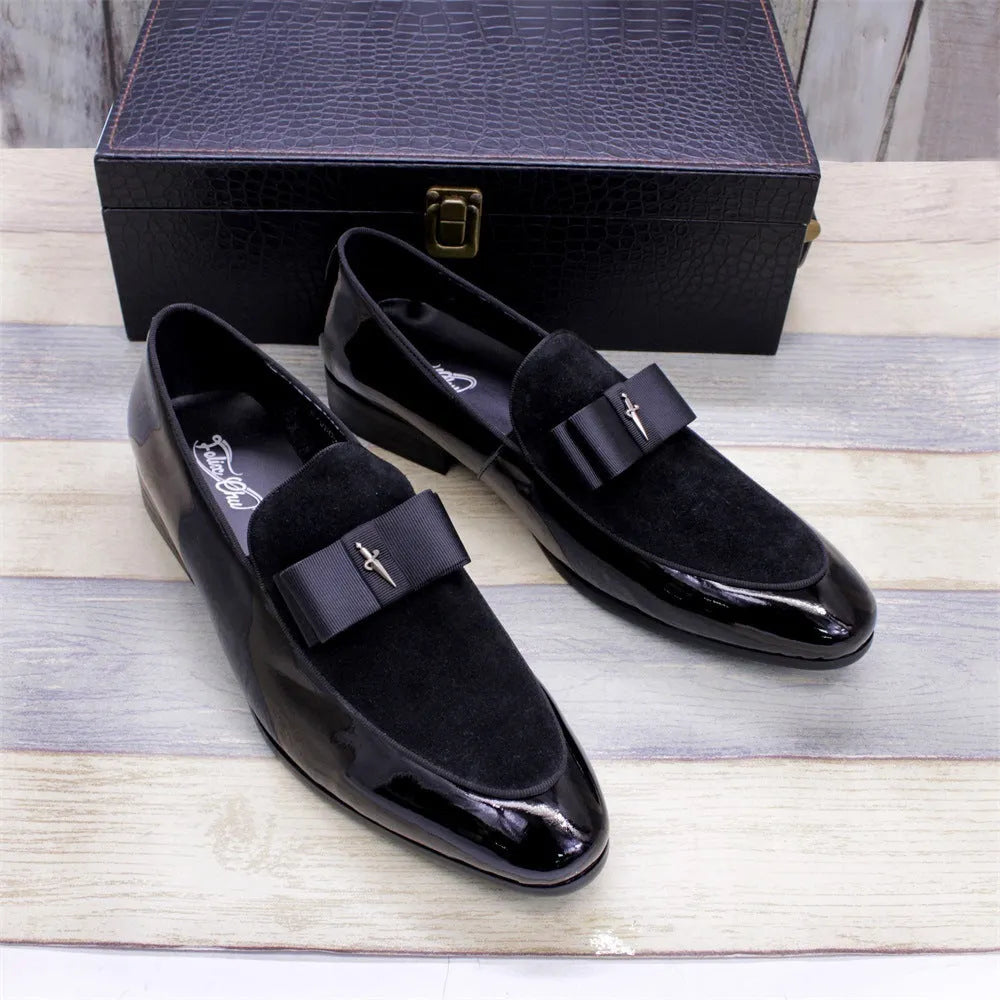 Men's black tassel loafer shoe with matte leather and glossy patent leather detail on a white background.