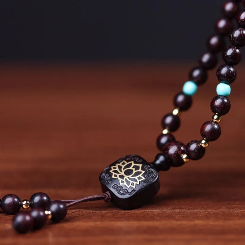 Zambia rosewood Buddha beads bracelet with 0.6 cm beads and flat lotus pendant on wooden surface