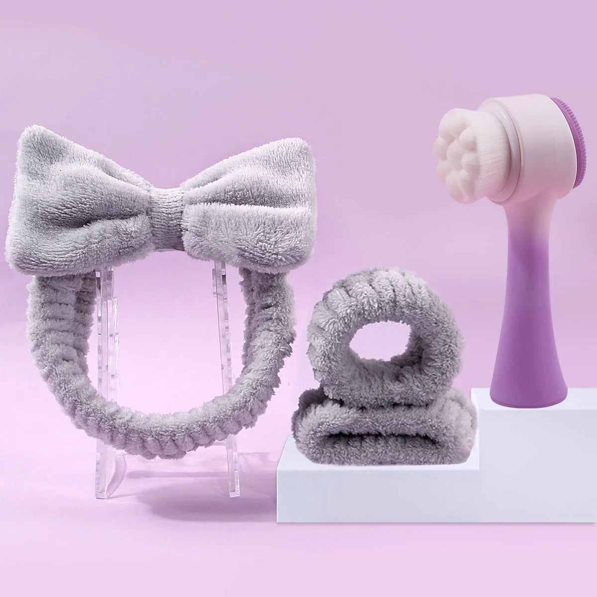 Three-piece facial skincare set showing a nylon brush and a coral fleece hair band in purple.