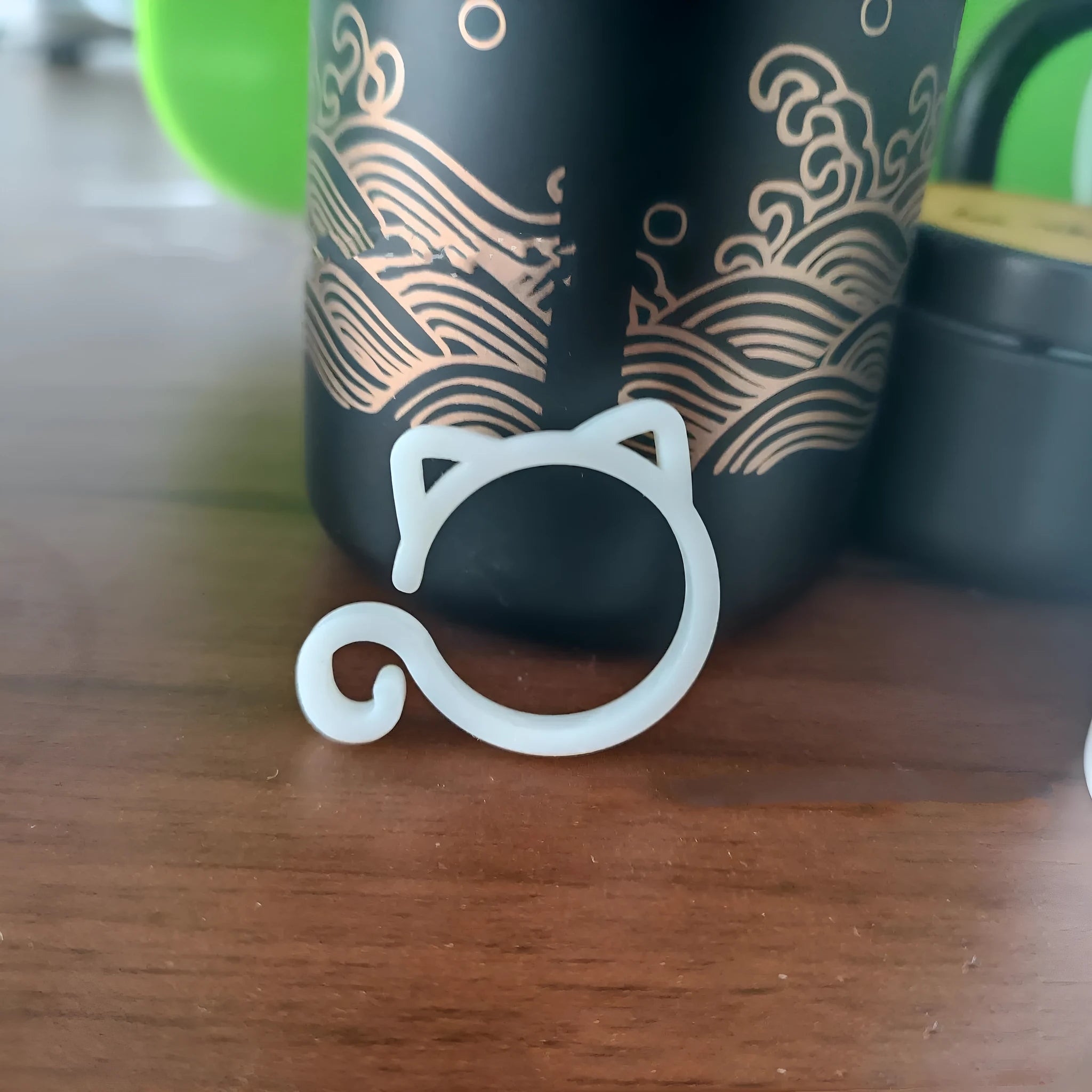 Colourful plastic cat-shaped clip for plant pots in red, yellow, green, and white.