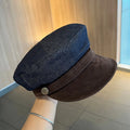 Dark blue denim octagonal newsboy flat cap with an adjustable strap, shown with a contrasting brown brim.
