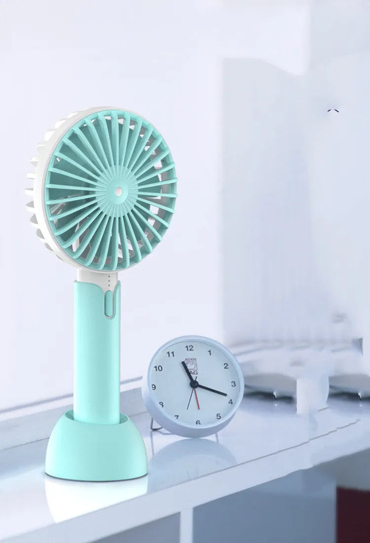 Blue handheld mini electric fan with USB cable, three-speed controls, and oscillation function on desktop