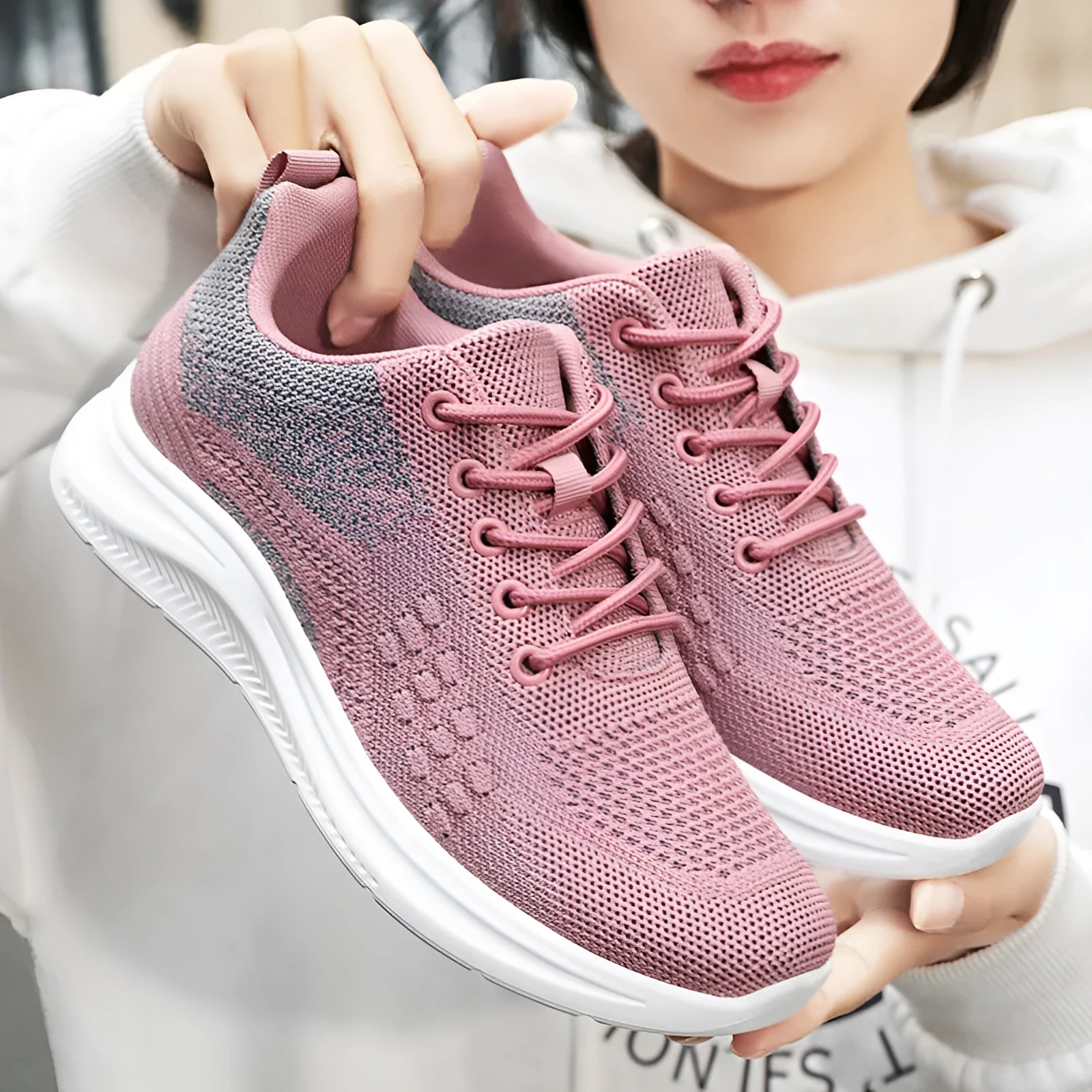 Women's black mesh sneakers with round toe and lace-up front, showing breathable construction and soft PVC sole
