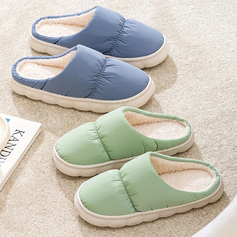 A pair of thick-soled house slippers with an artificial leather upper and plush lining, shown in a selection of colours.